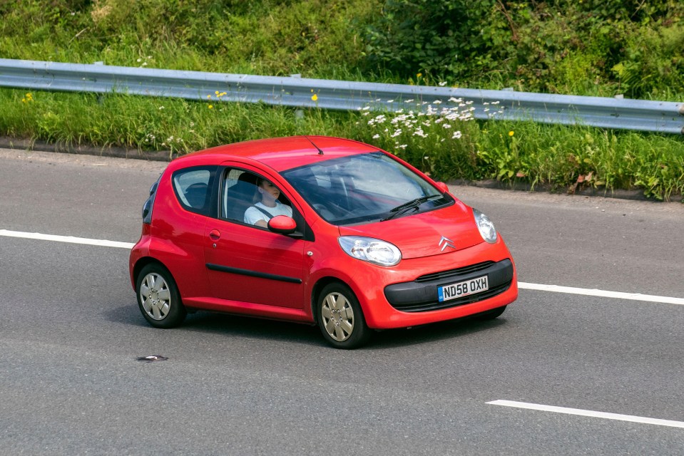 Red Citroen C1 driving on a UK motorway.