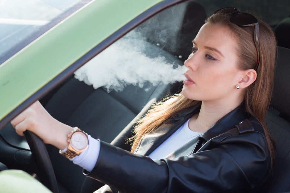 Woman Vaping behind the wheel