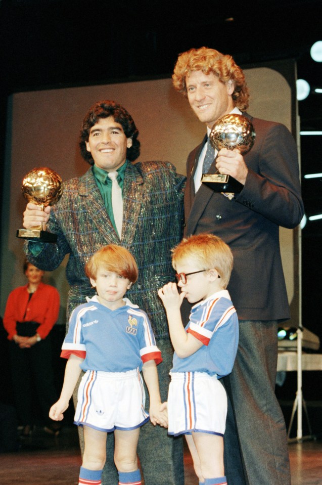 Maradona holds up his trophy alongside West German goalkeeper Harald Schumacher at the awards ceremony in Paris