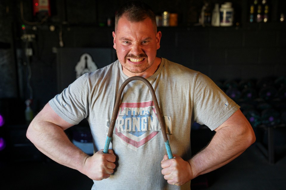 Strongman Paddy Haynes bends an iron bar as he shows off his impressive strength