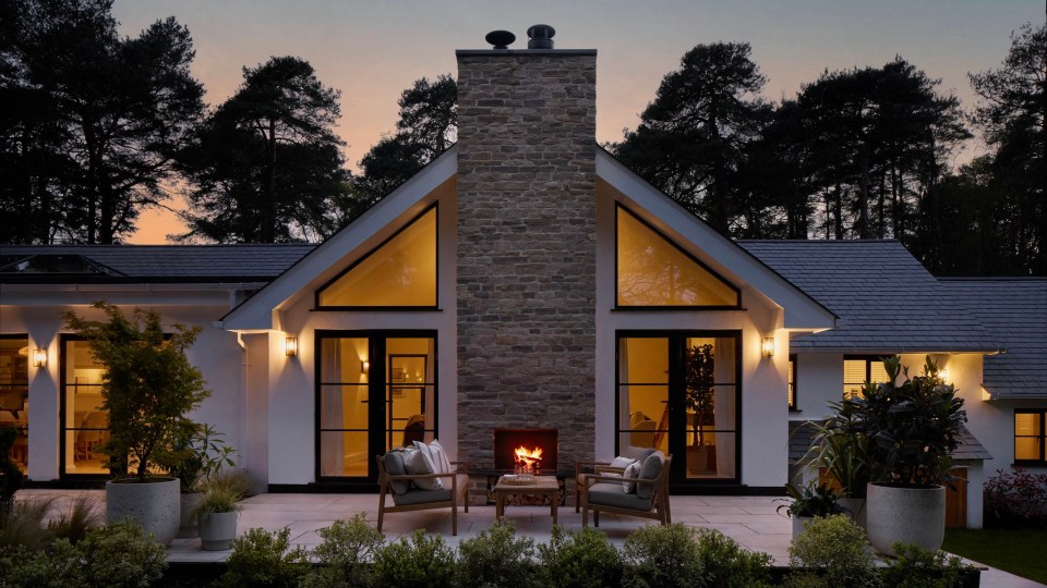 a house with a fireplace and chairs in front of it