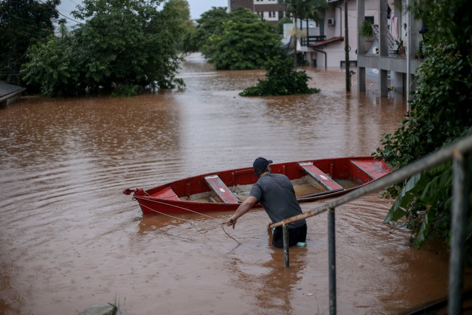 Lifeguards use boats to free trapped citizens from their drowned houses