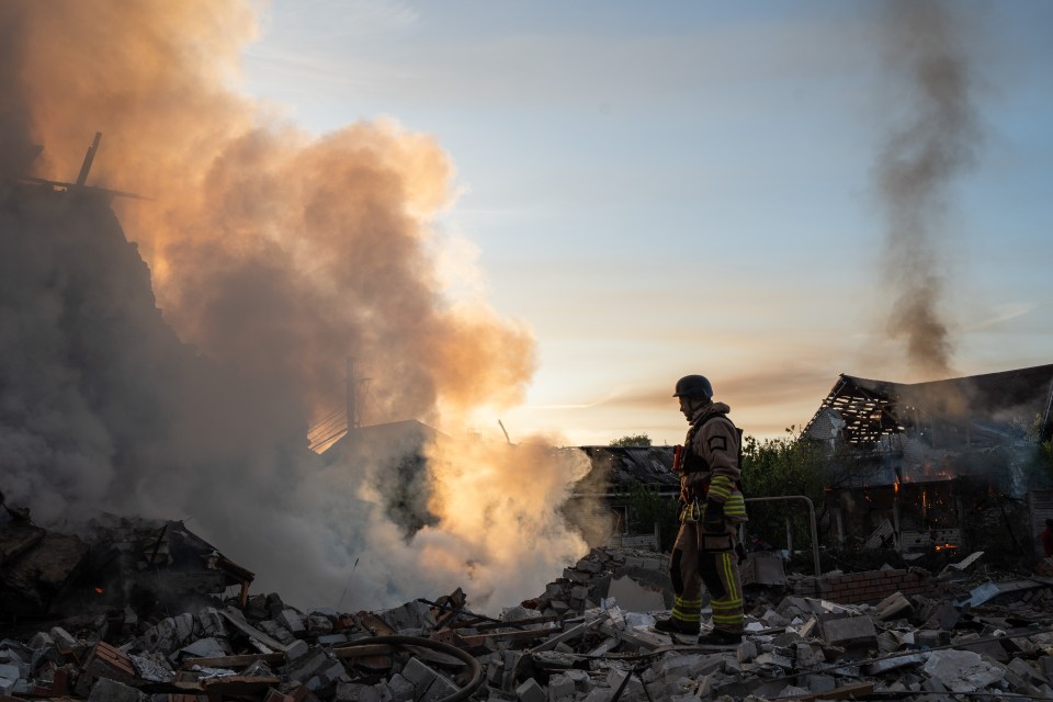 A fire at the site of a Russian missile strike in Kharkiv today