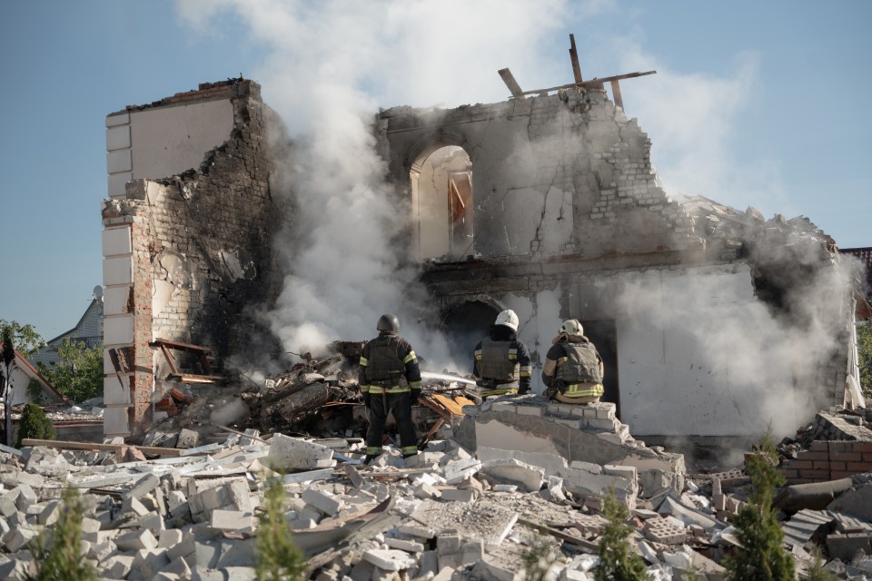 Firefighters finish extinguishing the fire at the site of a Russian missile strike