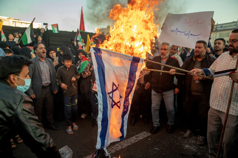 Iranian protestors set fire to American and Israeli flags as they take part in a protest in support of Palestinians in Gaza