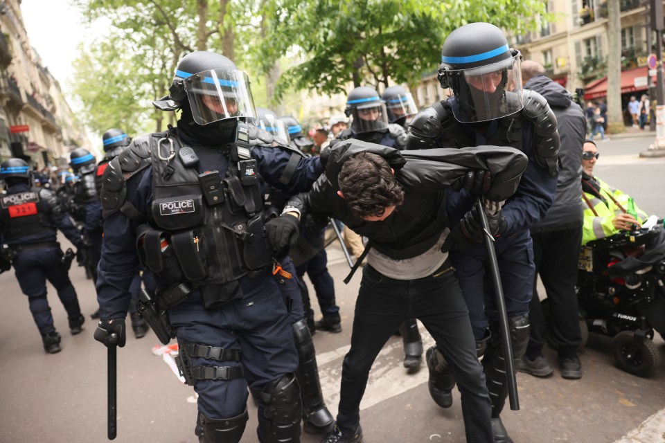 A protester is being detained by riot police officers during the May Day demonstration, Wednesday, May 1, 2024 in Paris. Thousands of protesters marched through the French capital, seeking better pay and working conditions. Pro-Palestinian groups and anti-Olympics activists joined the rally in Paris which will host the Summer Games in less than three months. (AP Photo/Thomas Padilla)