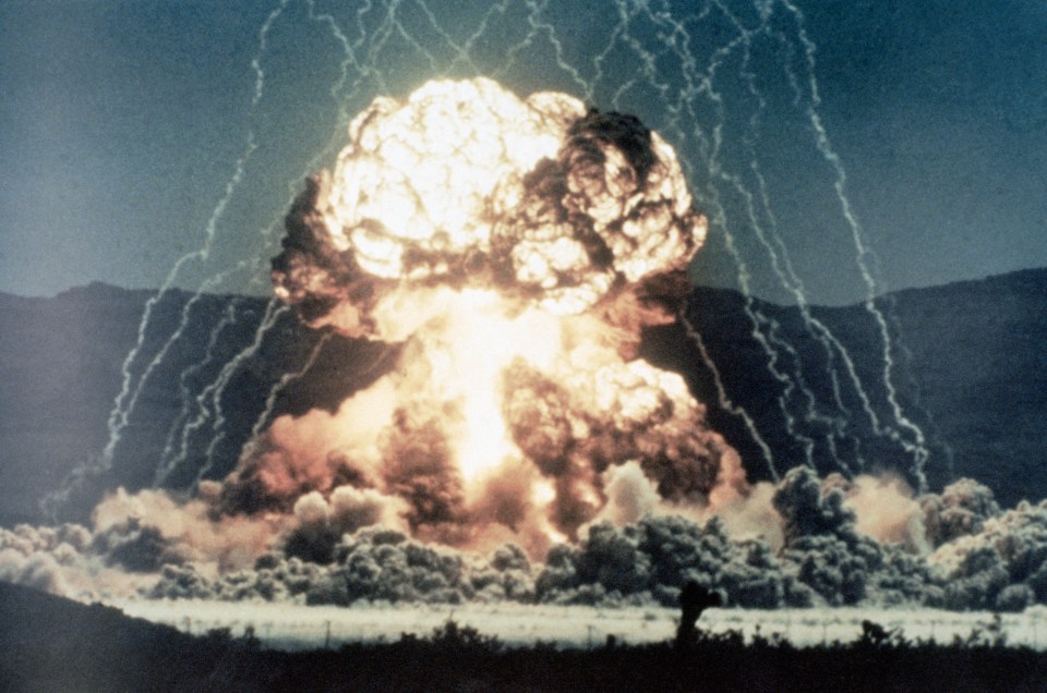 (Original Caption) Ground level view of a surface test of a nuclear device. Slide shows the beginning of a mushroom cloud, glowing intensly white, with lightning arcing from the ground to converge above the explosion. Undated color slide.