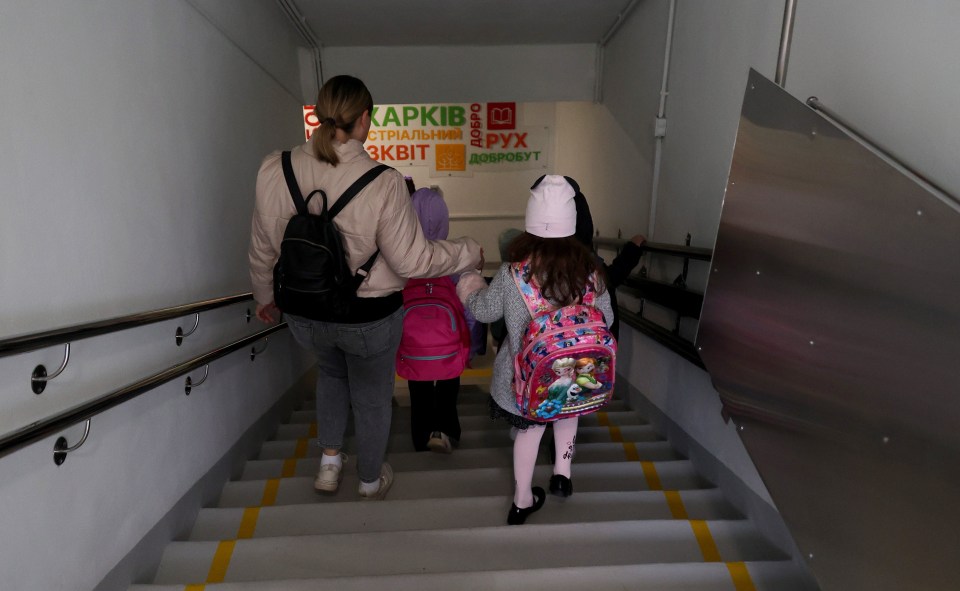 A woman and child venture down into one of Kharkiv’s underground schools