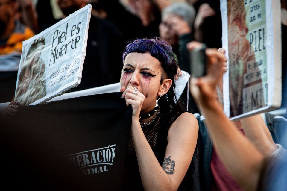 One activist is seen with blood tears painted on her face