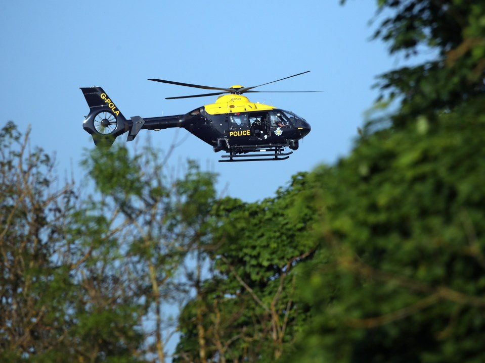 A police helicopter flying over the scene