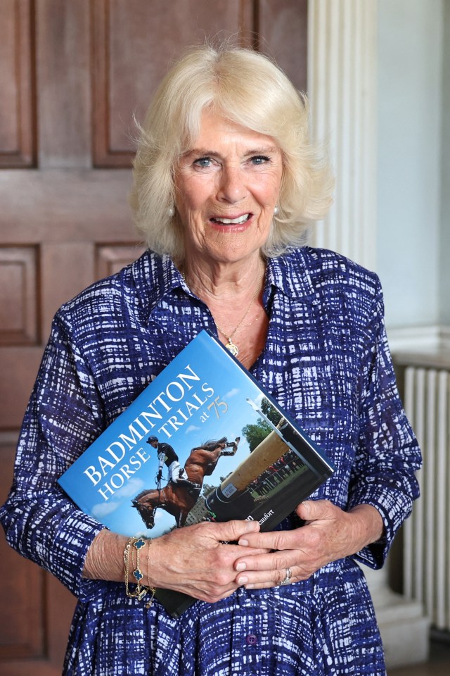 Queen Camilla holds a book celebrating Badminton Horse Trials’ 75-year history on the final day of the event