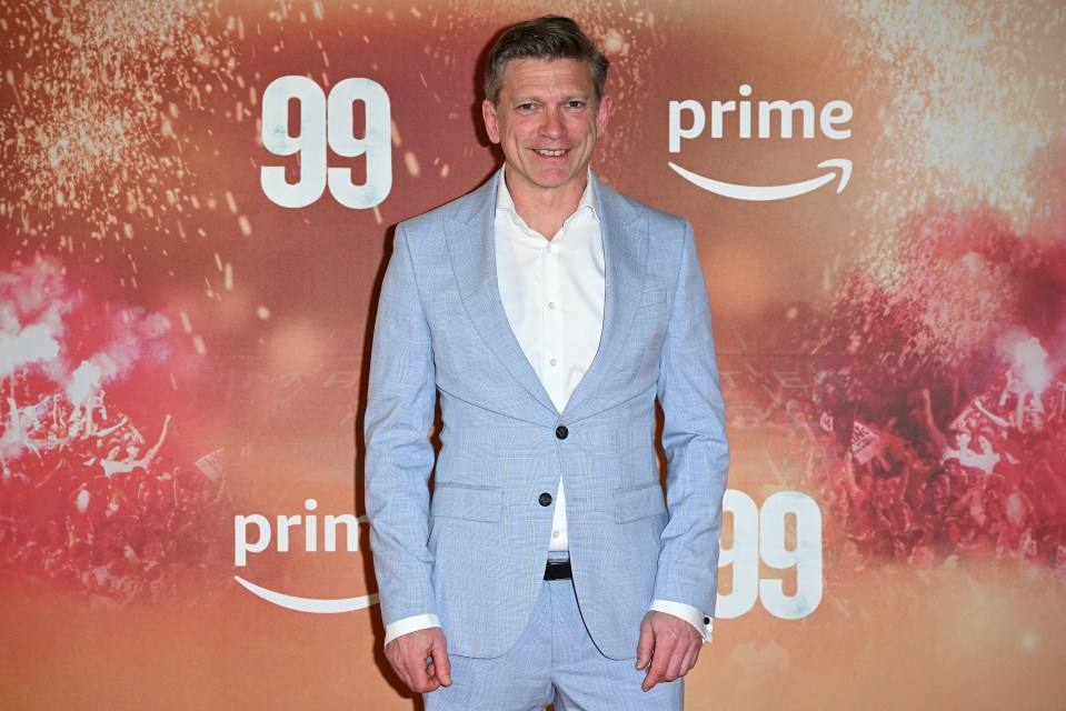 Jesper Blomqvist smiles in a grey, tie-less suit