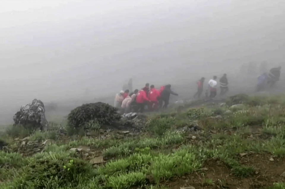 The bodies are carried through a fog-shrouded mountainous area of northwest Iran