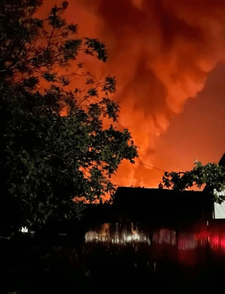 Orange plumes of smoke rise from a Russian oil depot in Yurovka