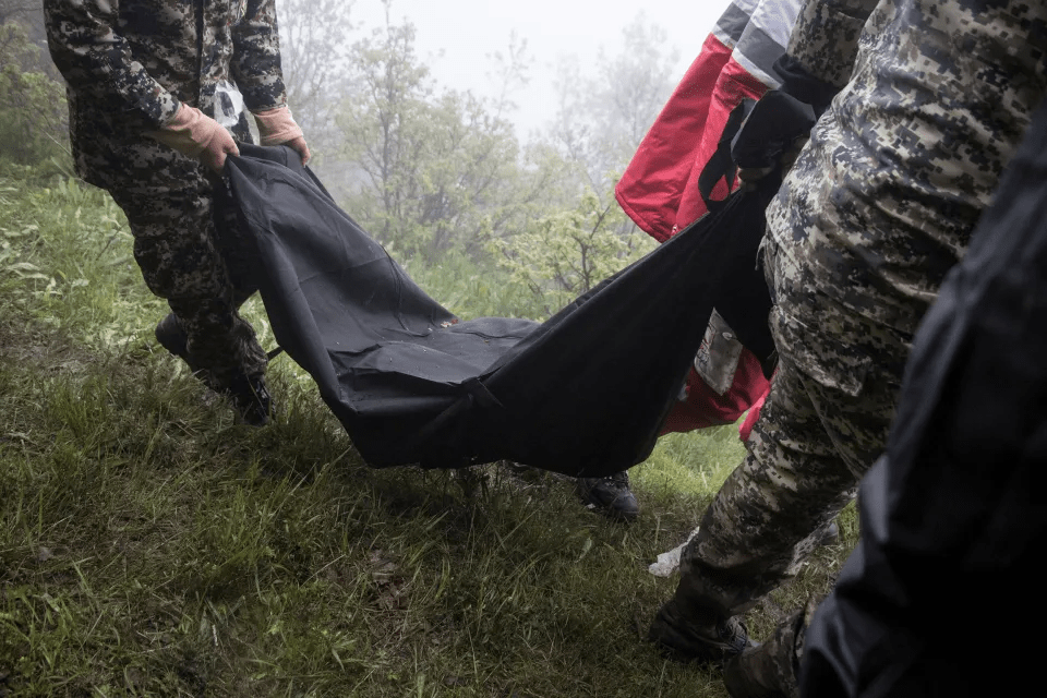 Rescuers carry a body after a helicopter carrying Raisi crashed in Varzaqan, East Azerbaijan province