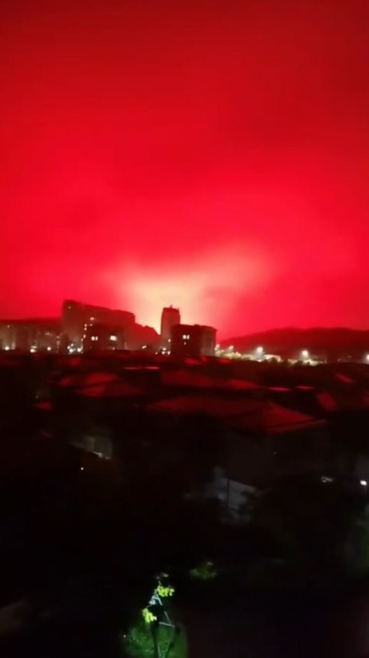 a red sky is visible over a city at night .