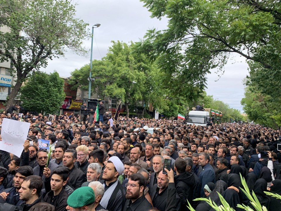 Residents are spotted holding Iranian flags in a funeral procession for Raisi