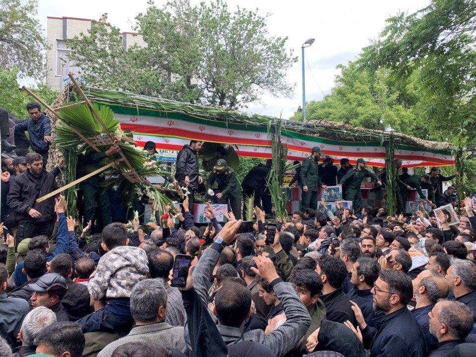 The coffins of President Raisi and seven members of his entourage are carried through  a funeral procession on a truck in Tabriz