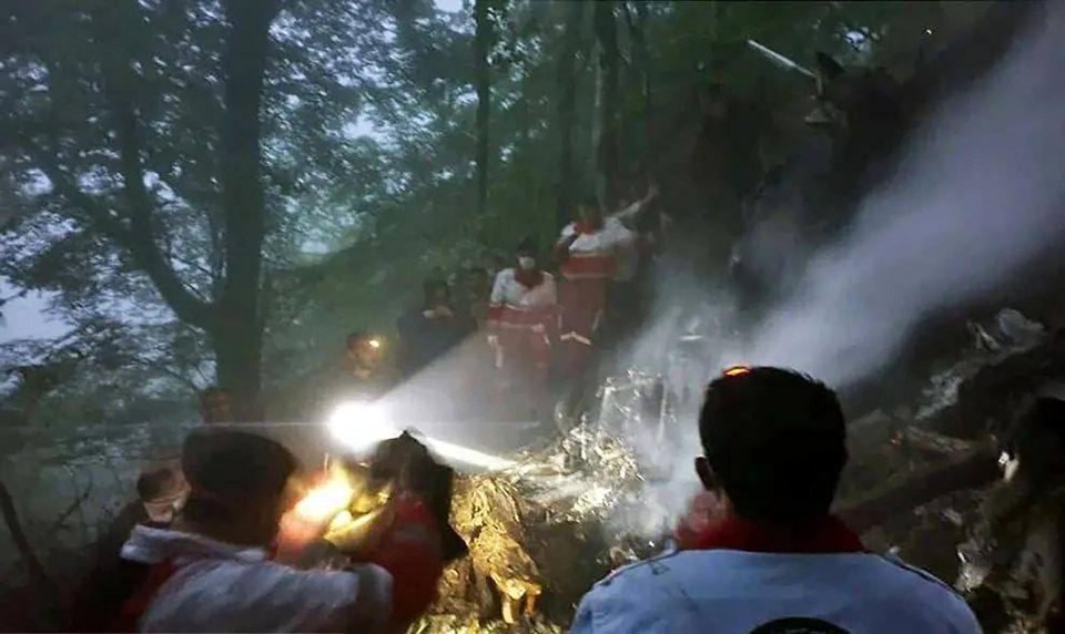 Search and rescue personnel inspect the helicopter crash site