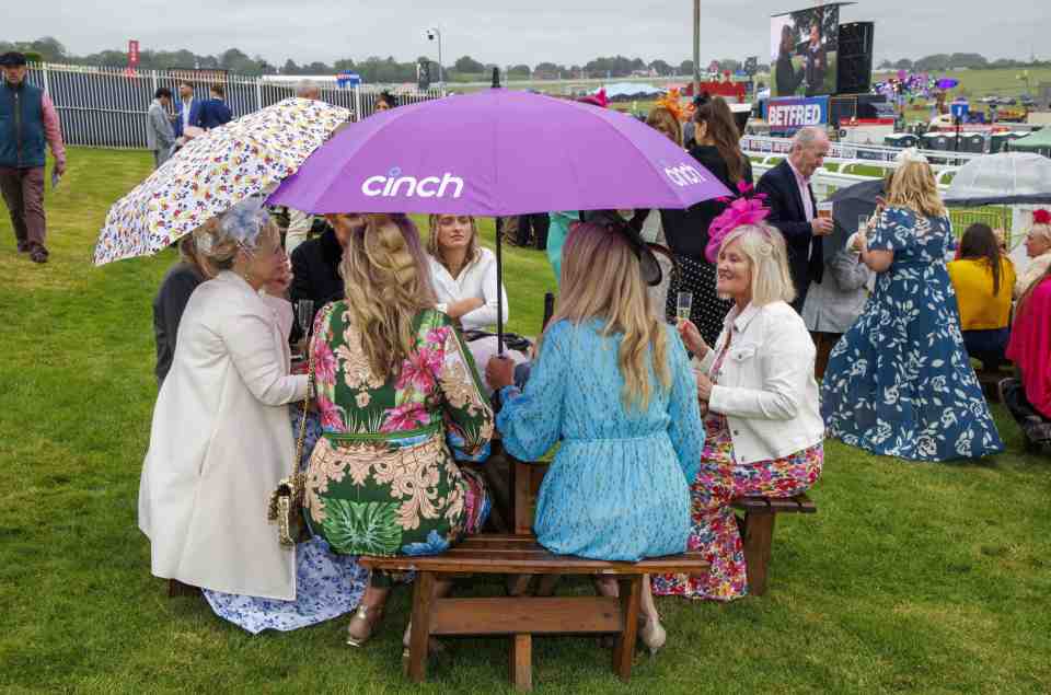 Brollies went up as chic guests rested their feet at Epsom