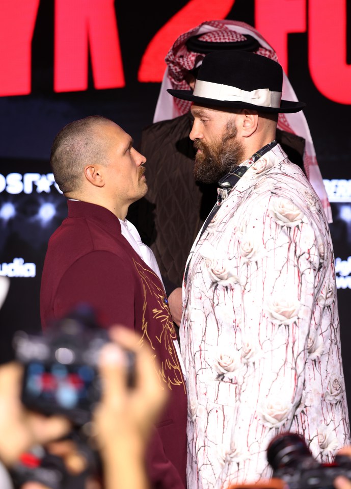 Oleksandr Usyk and Tyson Fury face off at a press conference.