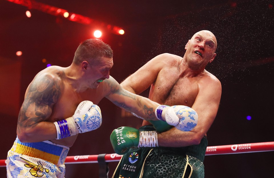 Tyson Fury and Oleksandr Usyk face each other at a press conference.