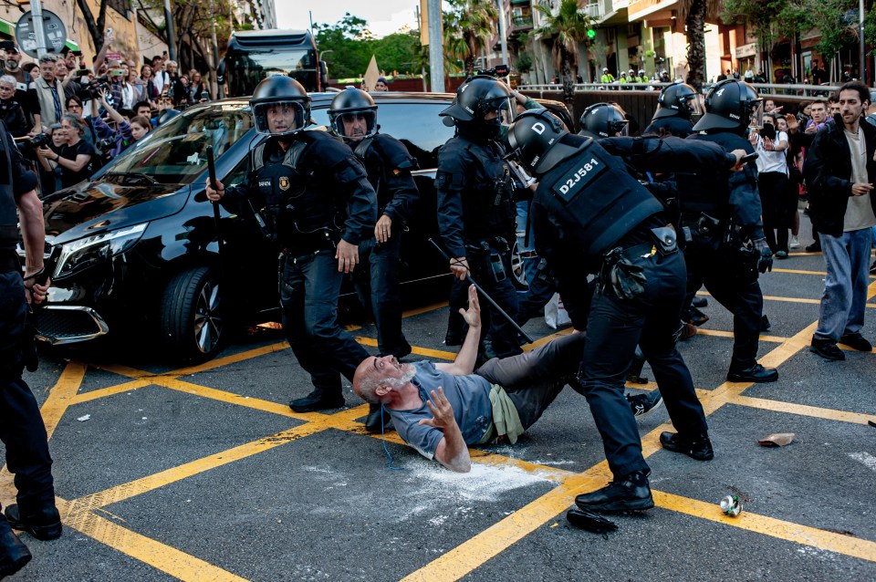 A demonstrator raises his hands in the air before he is handcuffed