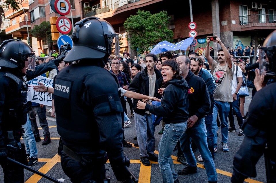 A demonstrator screams in the faces of police