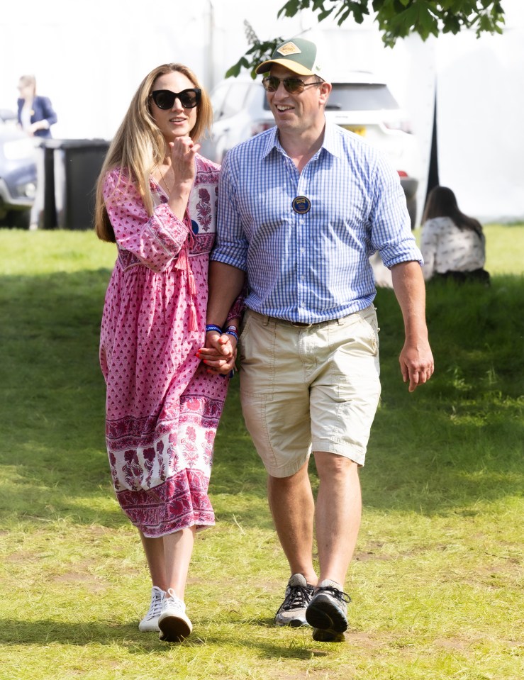 Peter Phillips and Harriet Sperling stroll hand-in-hand among the crowds at Badminton