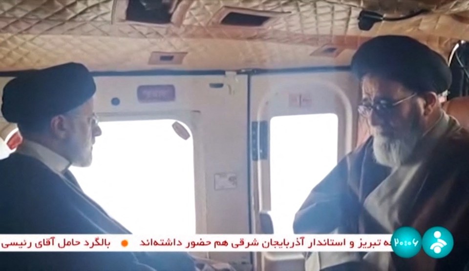 President Ebrahim Raisi (L) with an unidentified member of his delegation on board a helicopter on Sunday before the crash