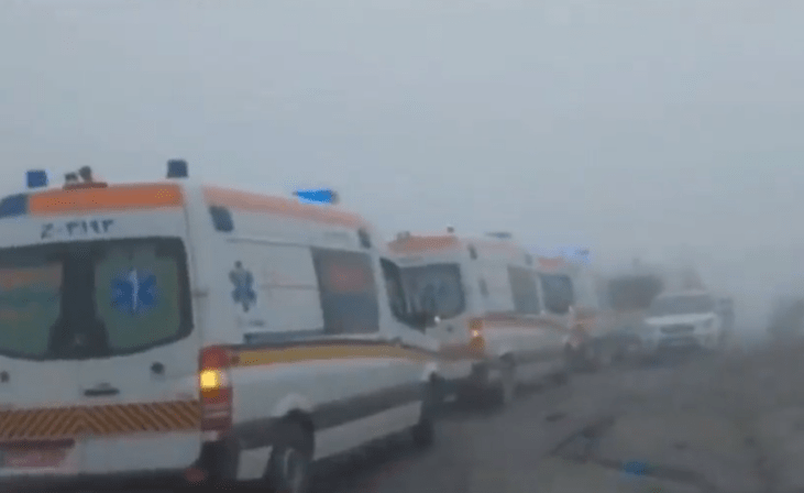 Ambulances and rescue vehicles lined up in the area of the crash