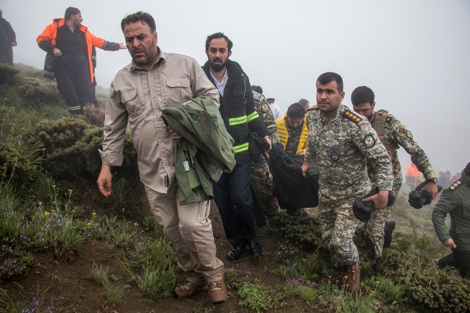 Rescue team members recover the body of a victim from the crash site