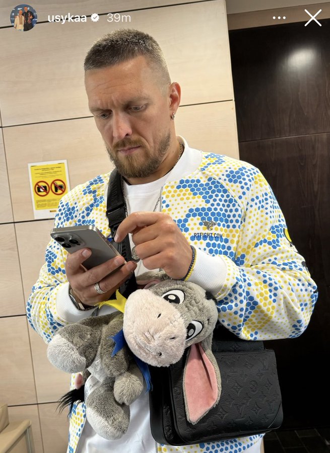 Oleksandr Usyk carrying an Eeyore stuffed animal.