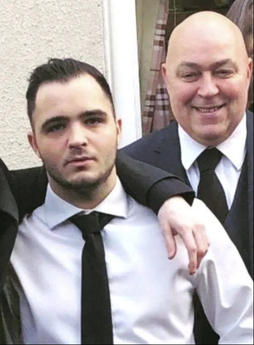 two men in suits and ties are posing for a picture together .