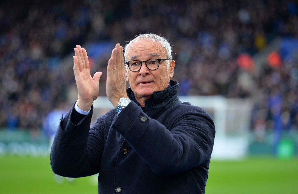 a man wearing glasses and a watch applauds on a soccer field