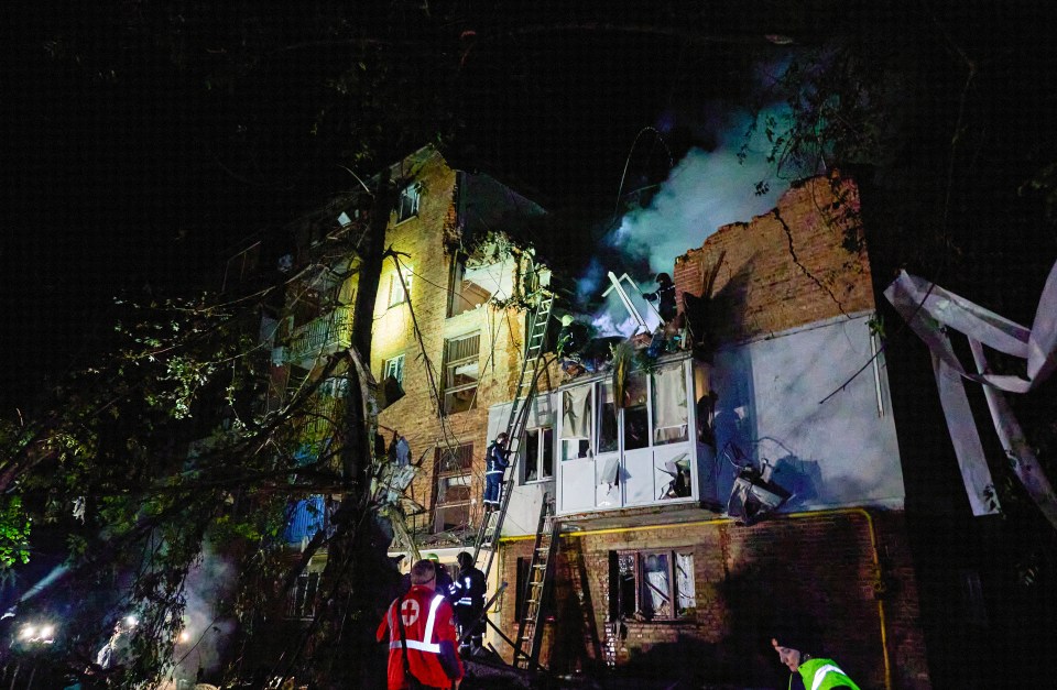 Ukrainian rescuers work at the site of the shelling of a residential building in Kharkiv