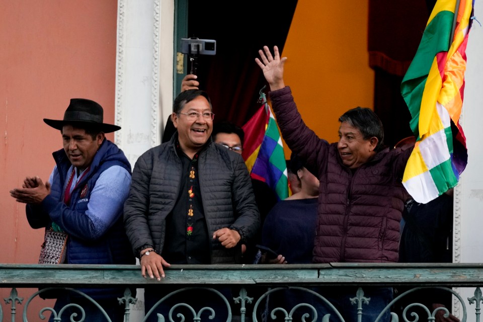 Bolivian President Luis Arce, centre, accompanied by Vice President David Choquehuanca, right, acknowledge supporters as they stand on a balcony of the government palace in La Paz, Bolivia