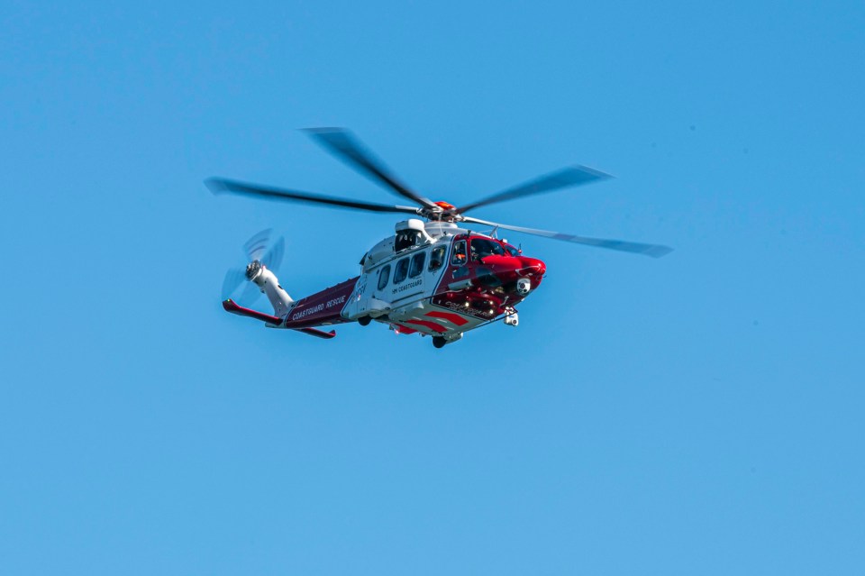 A coastguard helicopter scours the area from above