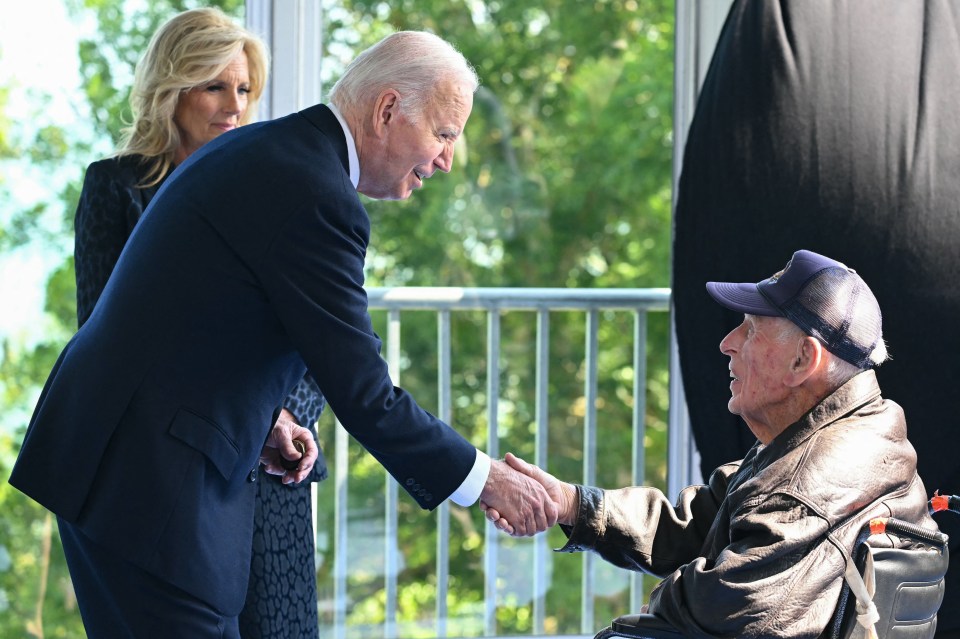 Joe Biden and US First Lady Jill Biden speak with a US veteran as they attended the ceremony