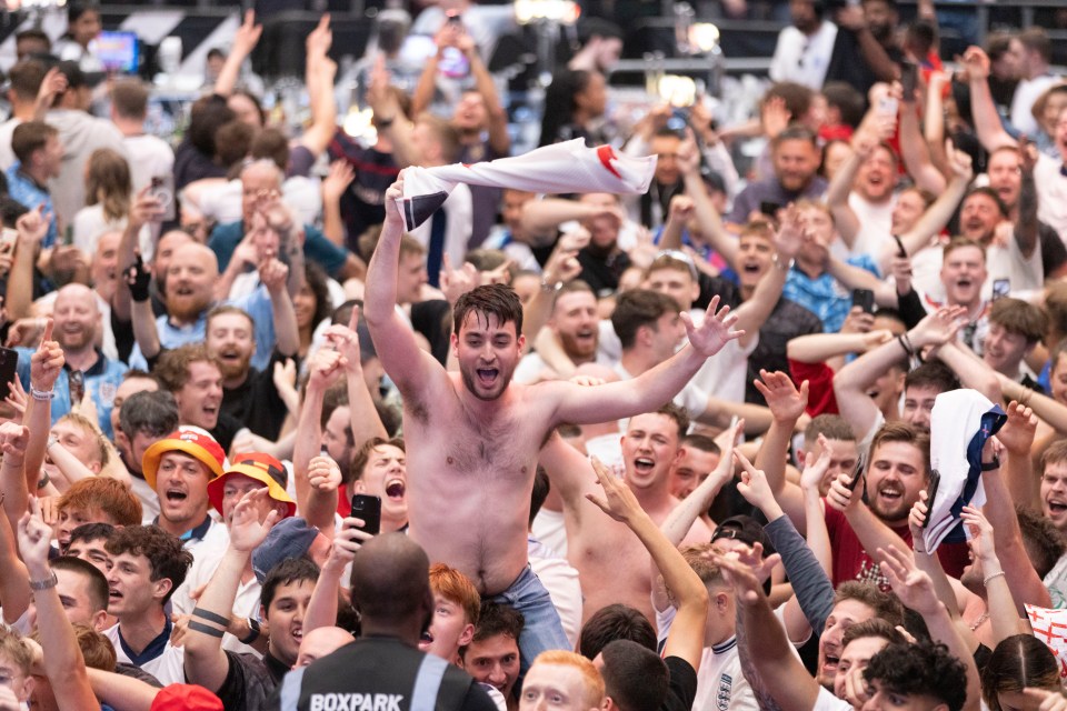 a shirtless man is being lifted in the air by a boxpark security guard