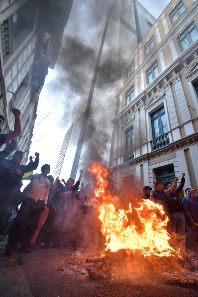 Demonstrators set a fire in the streets amid clashes with the military police at Plaza Murillo