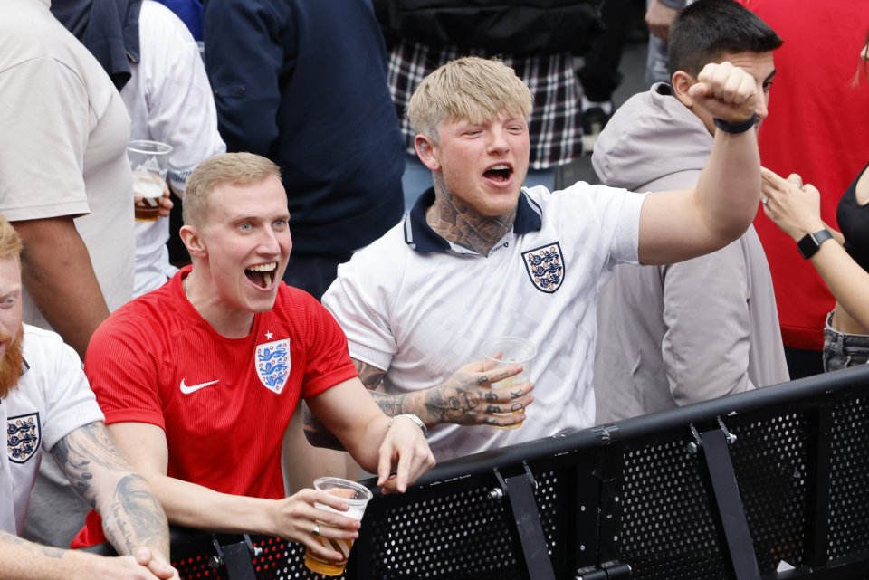 Supporters cheer on the big screen at Boxpark