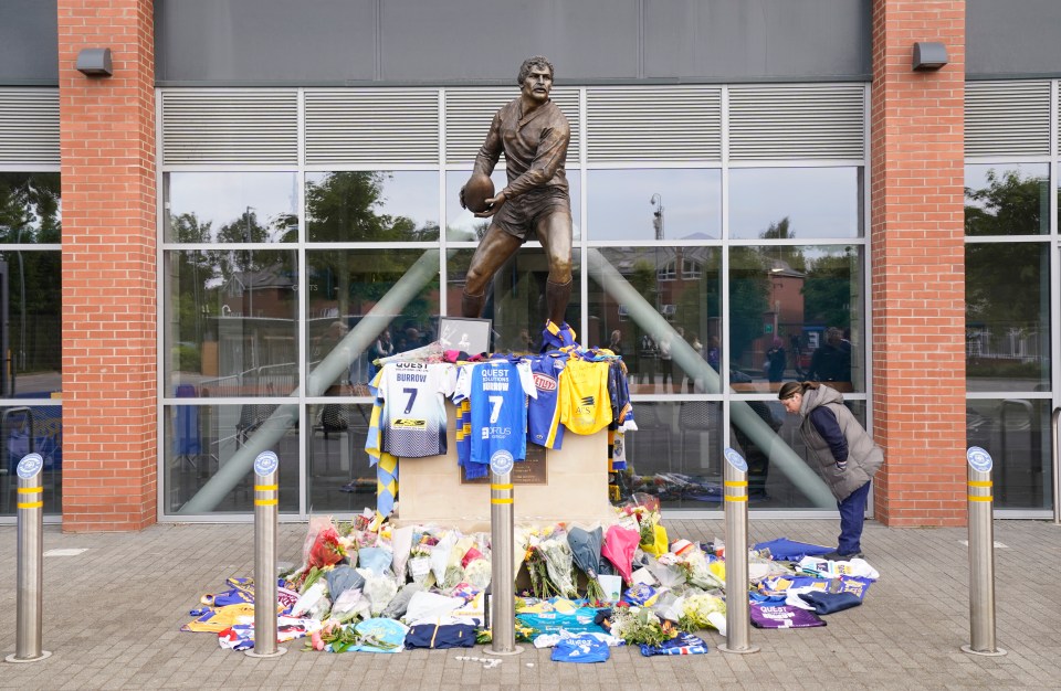 A member of the public views the flowers, messages and other tributes left at Headingley Stadium in Leeds