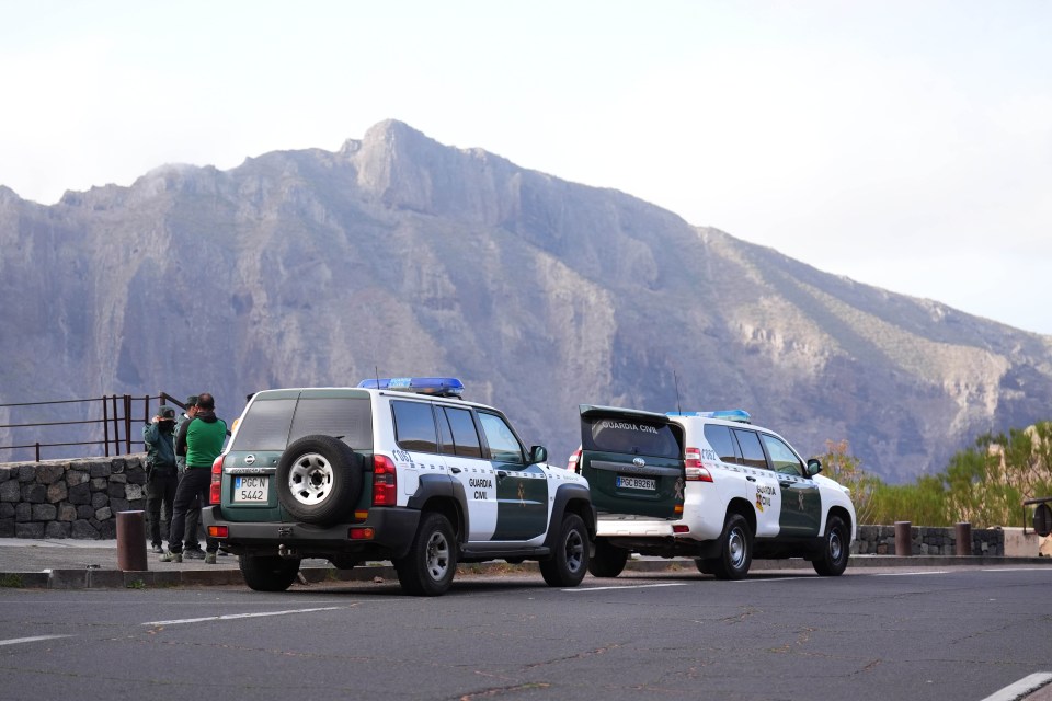 a group of guardia civil officers standing around a vehicle