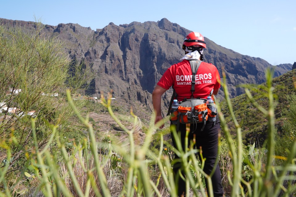 a man wearing a red shirt that says bomberos santiago del teide