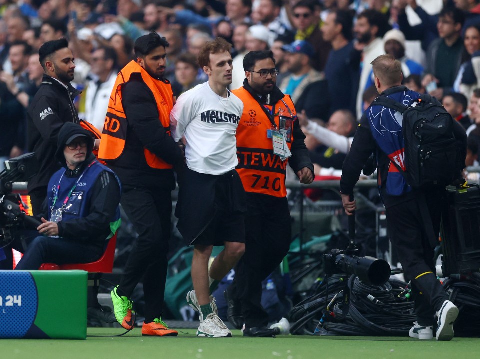 Another pitch invader being frogmarched off the pitch