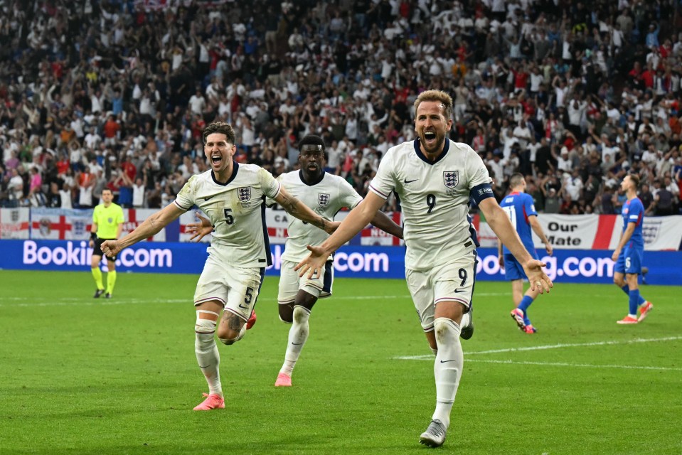 soccer players on a field with an ad for booking.com in the background