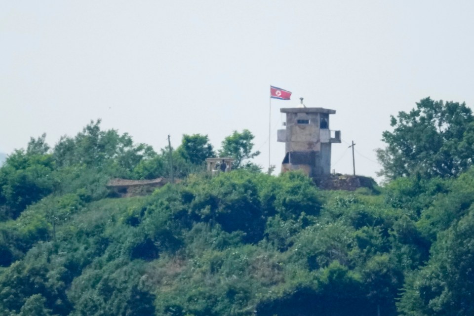 a tower on top of a hill with a flag on top of it