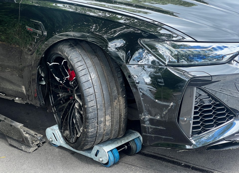 a black car with a wheel on a roller