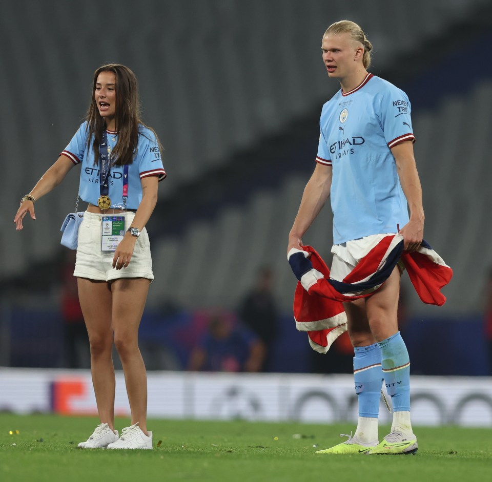 a man in an etihad jersey stands next to a woman